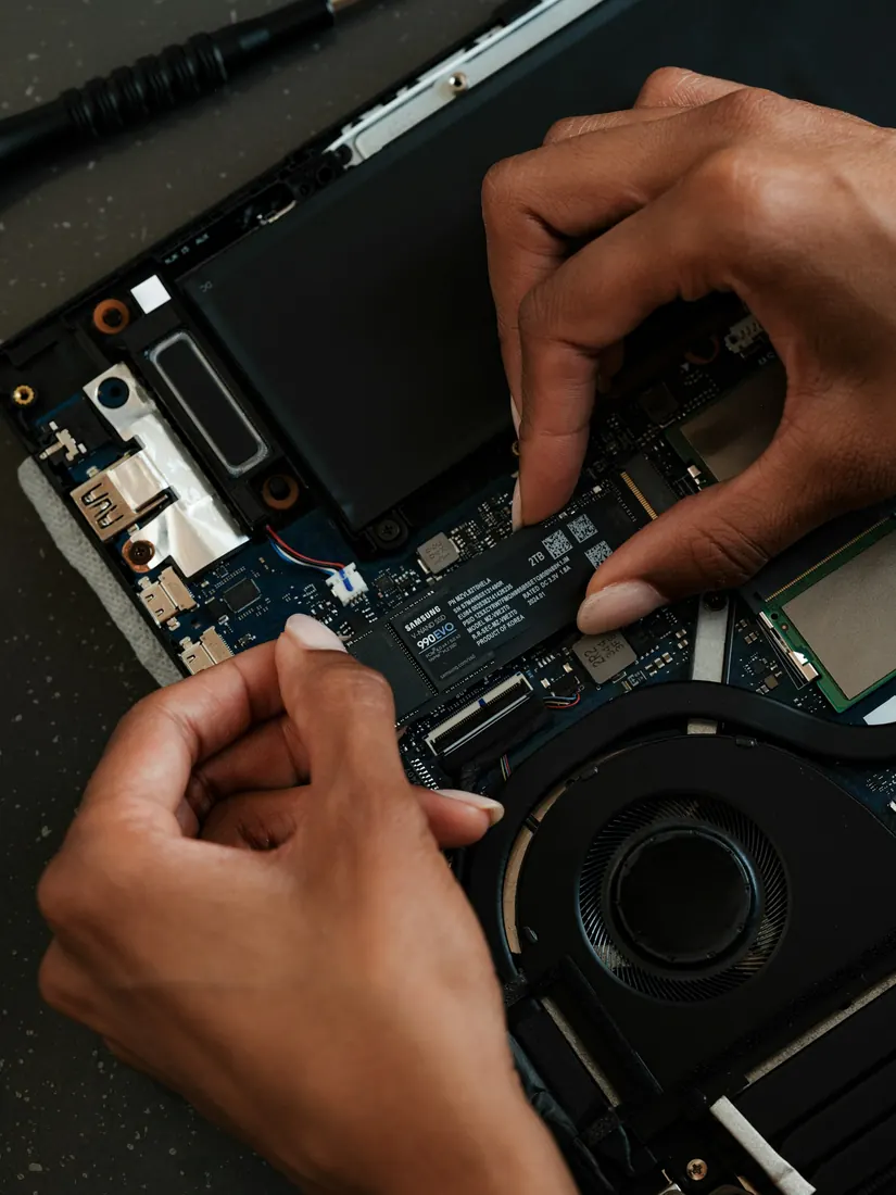 Técnico instalando disco SSD M.2 en notebook abierto
